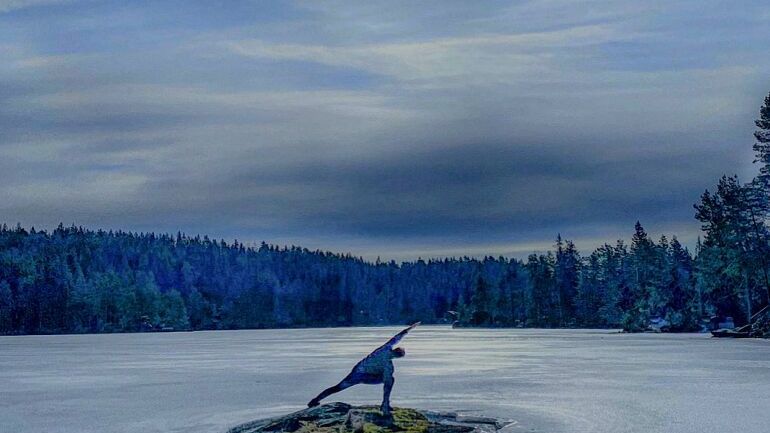 Person som praktiserer yoga ved et vintervann.